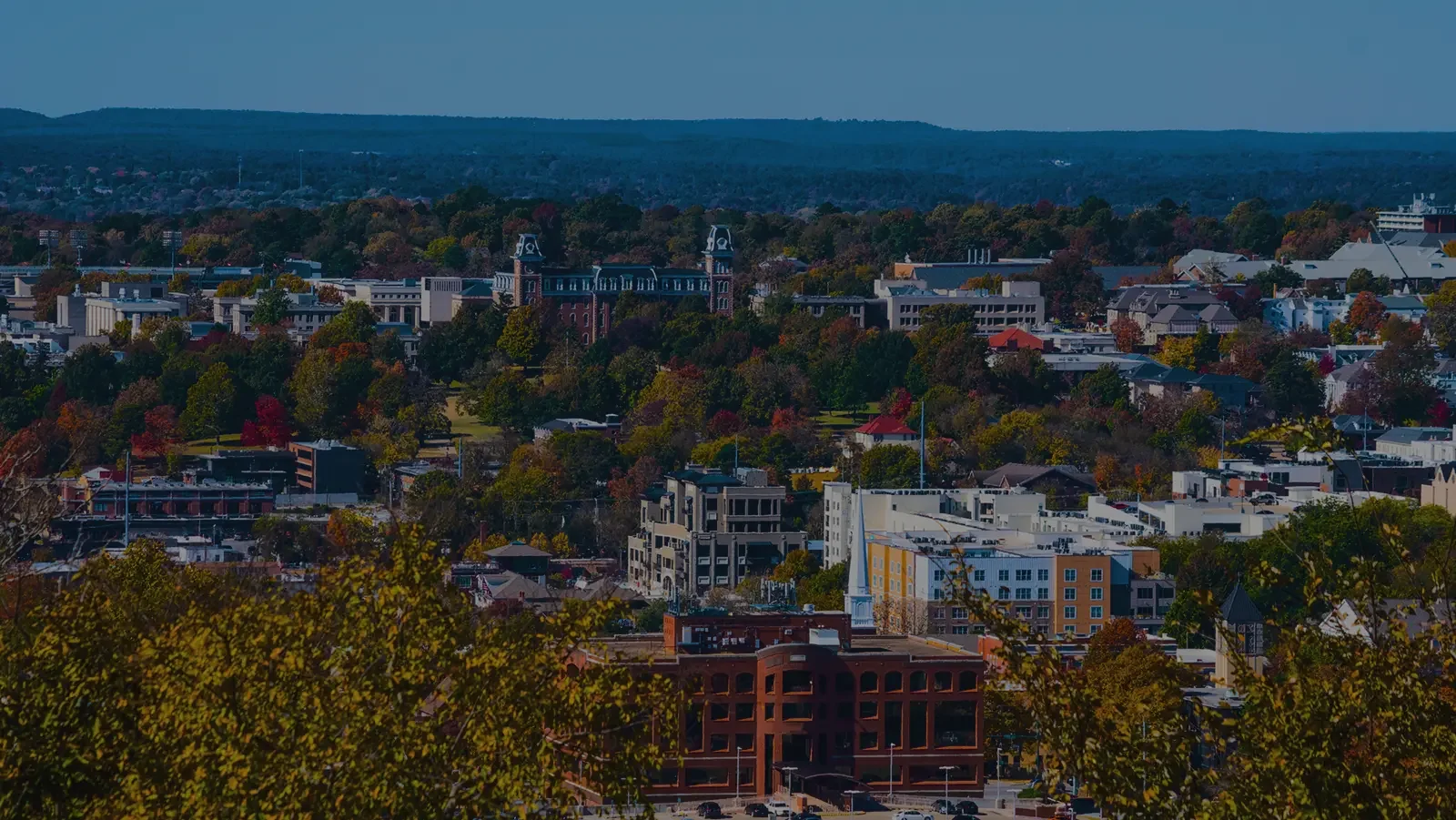 a horizon image of Fayetteville, Arkansas with buildings, trees and sky