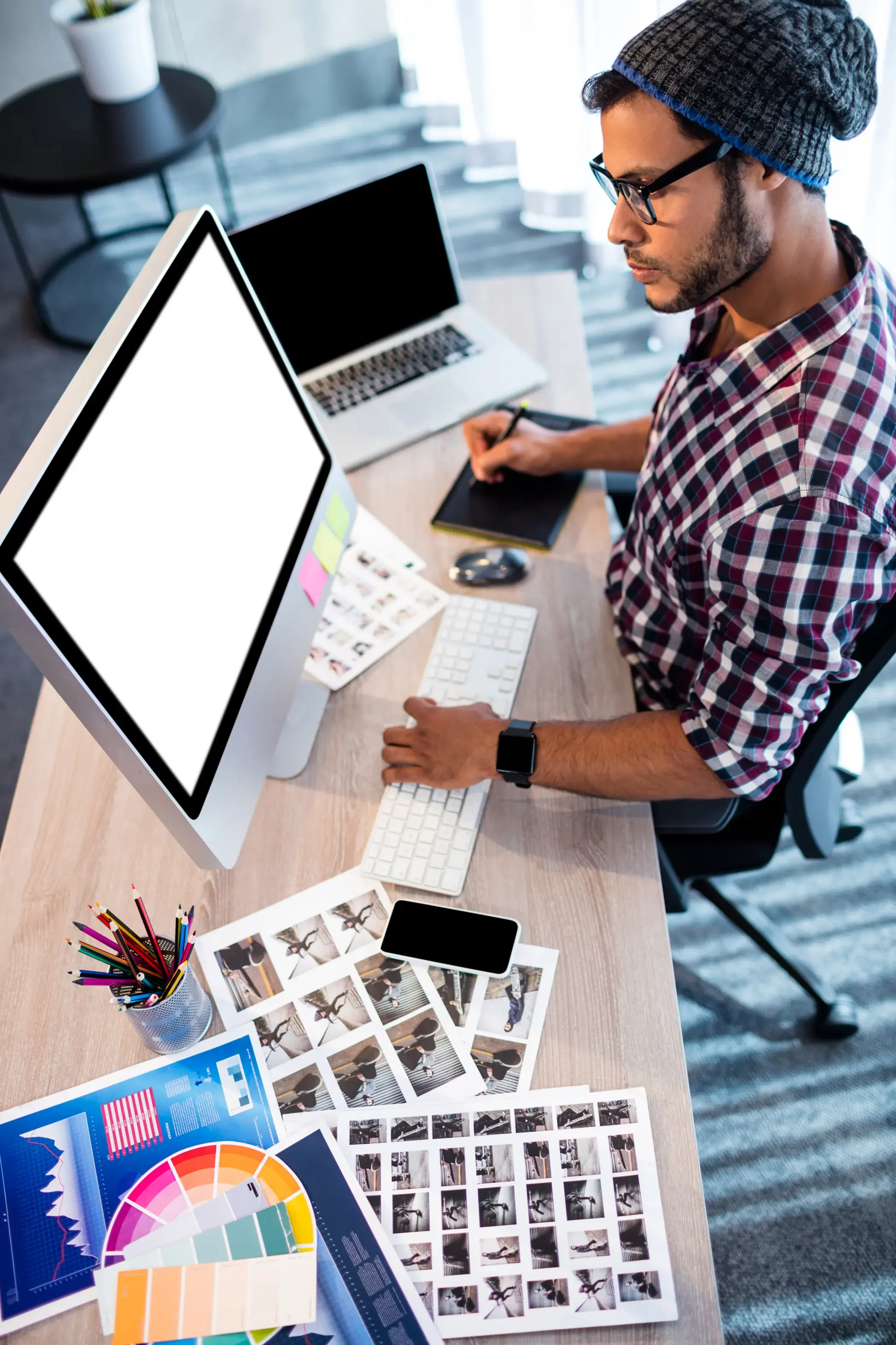 man working at desk with computer and web design supplies