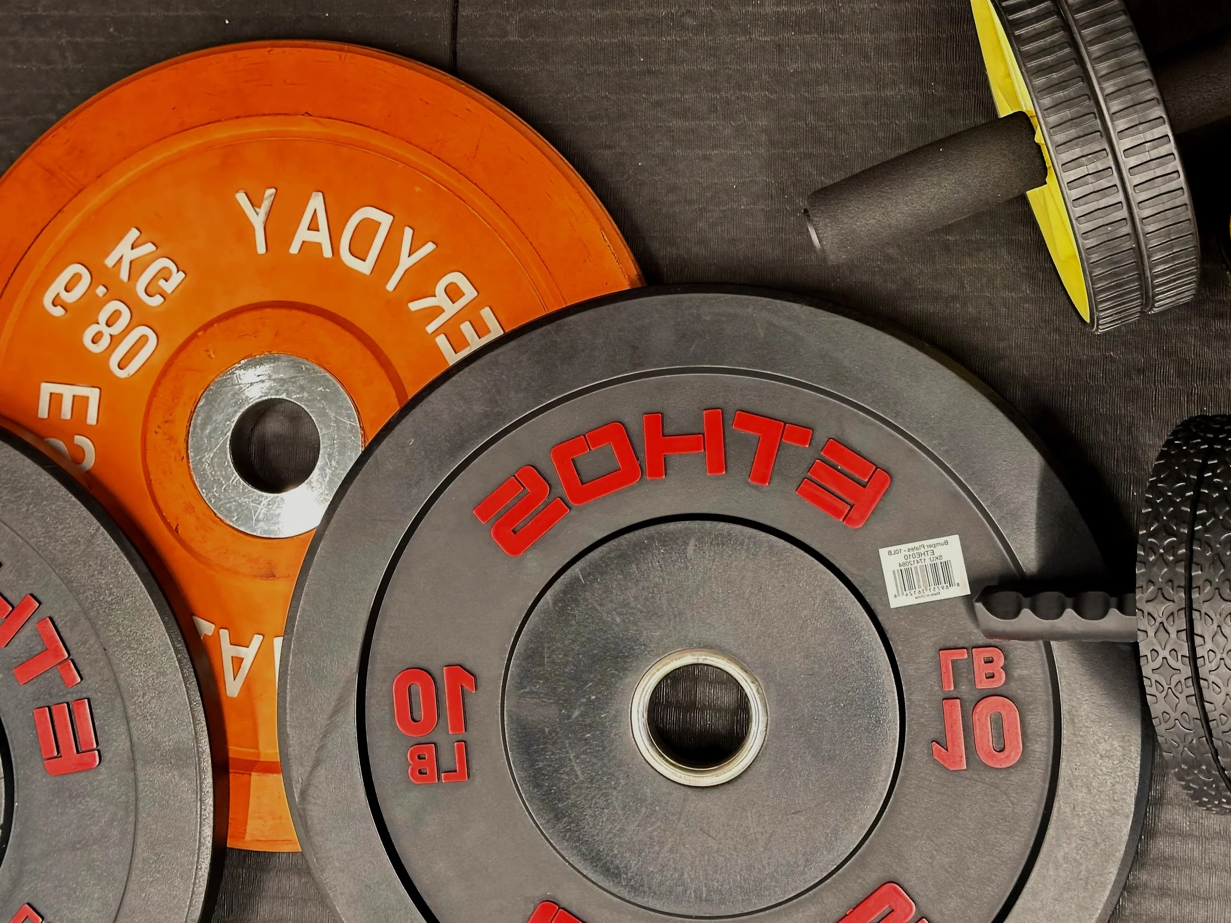 Close-up of multiple weight plates stacked together, with labels indicating their weight in pounds.