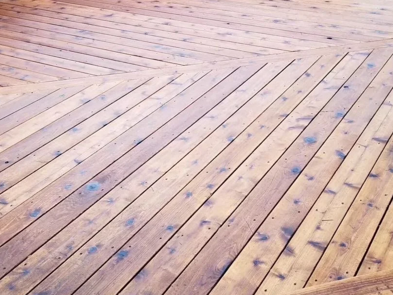 Close-up of a wooden deck with evenly spaced planks and visible knots.