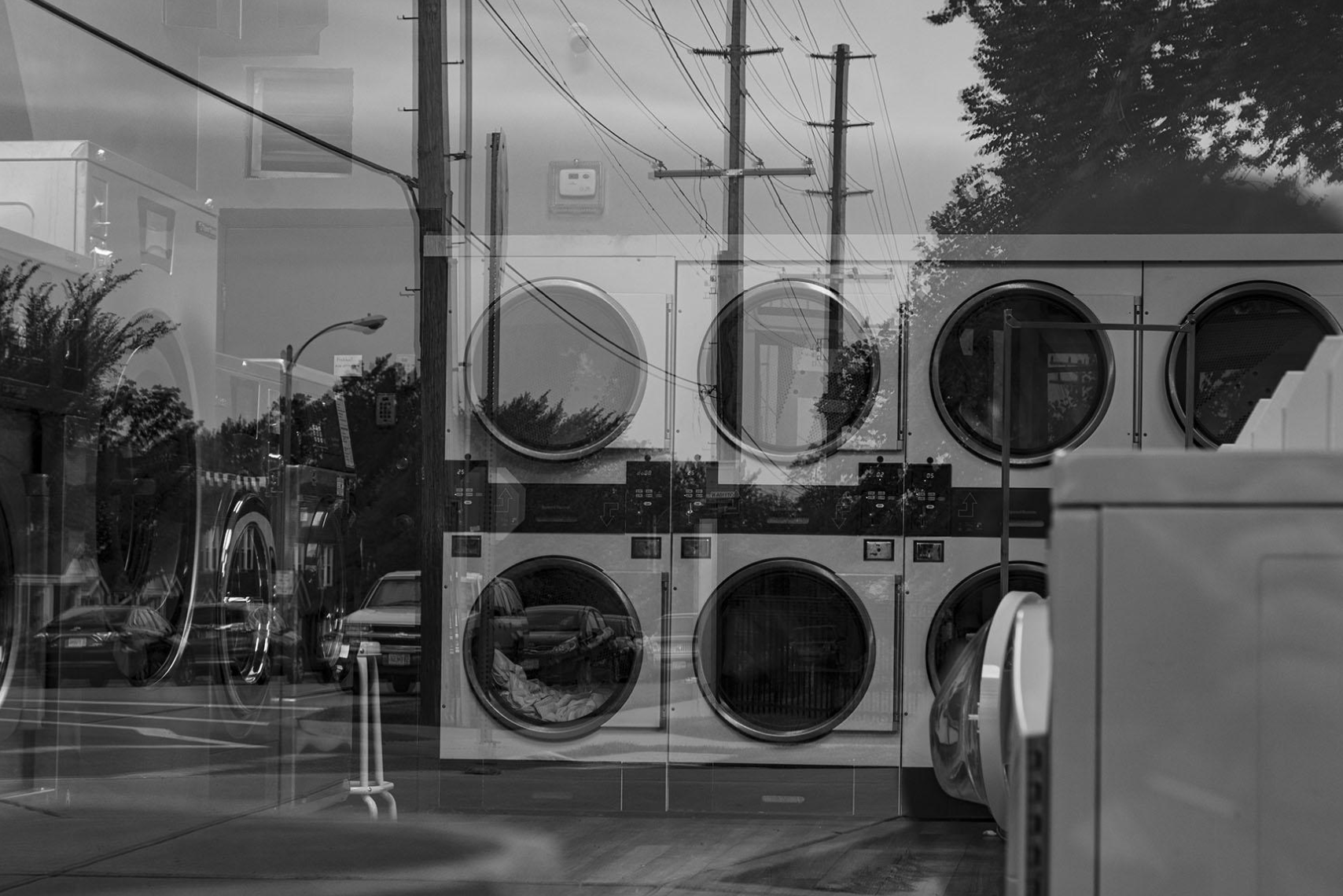 Reflections in the window at the Bellevue Laundry Mat on July 24, 2023, in St. Louis, Mo. This image appears in my photo essay exploring my relationship to my childhood neighborhood as a young adult. 