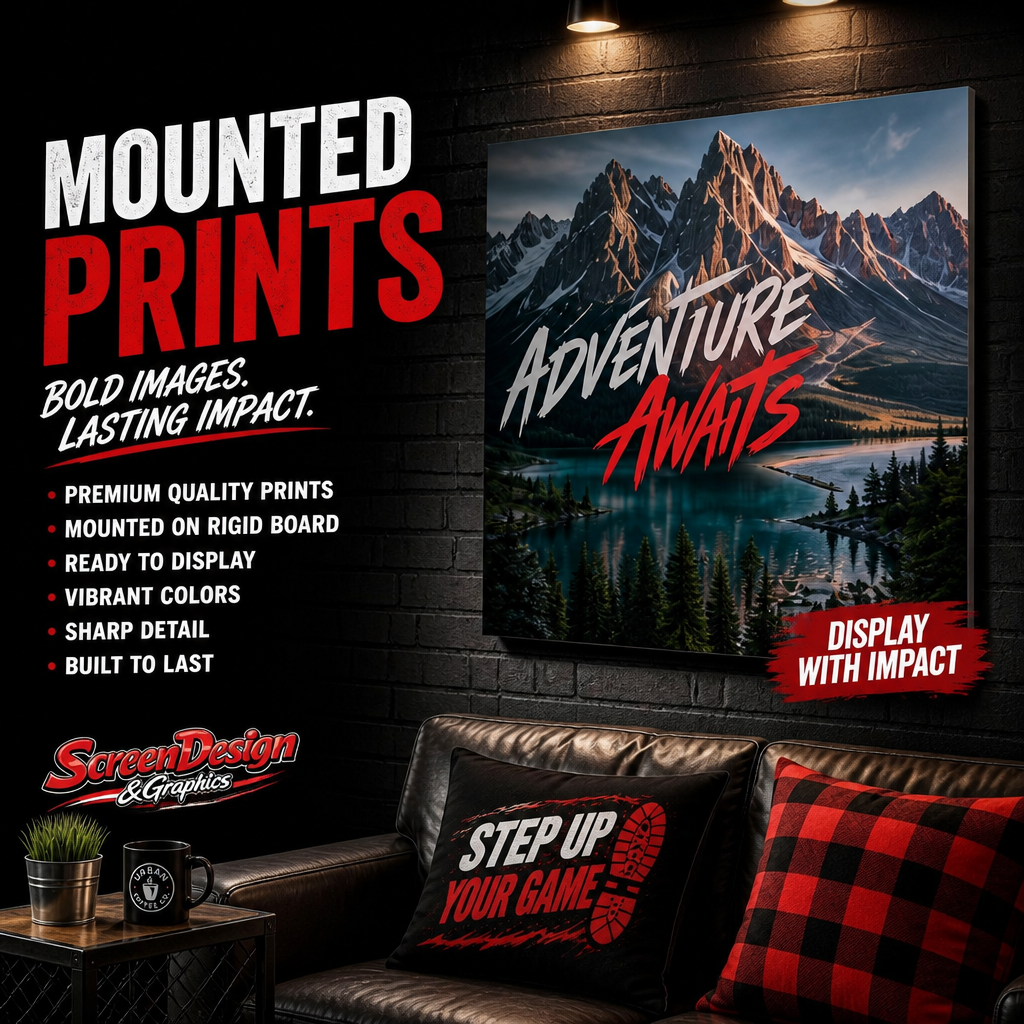 An advertisement for mounted prints featuring mountain landscape art with the text 'Adventure Awaits'. The ad highlights qualities like premium quality, vibrant colors, sharp detail, and durability. The setting includes a modern living room with a black leather couch, decorative pillows, a coffee table with a plant, a mug, and a wall-mounted print, all under focused lighting.