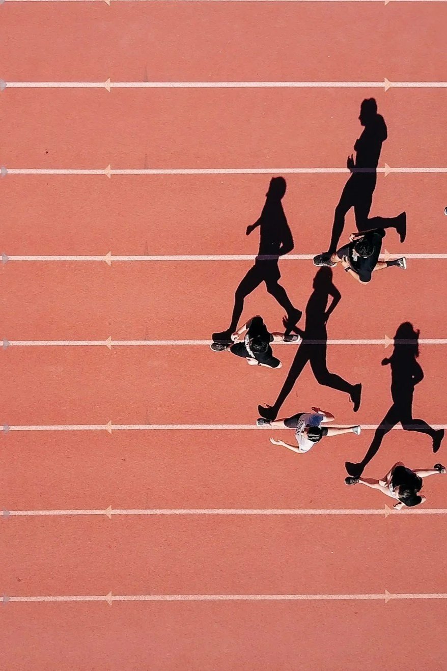 Runners on an athletics track representing sports performance, focus and achieving personal goals.