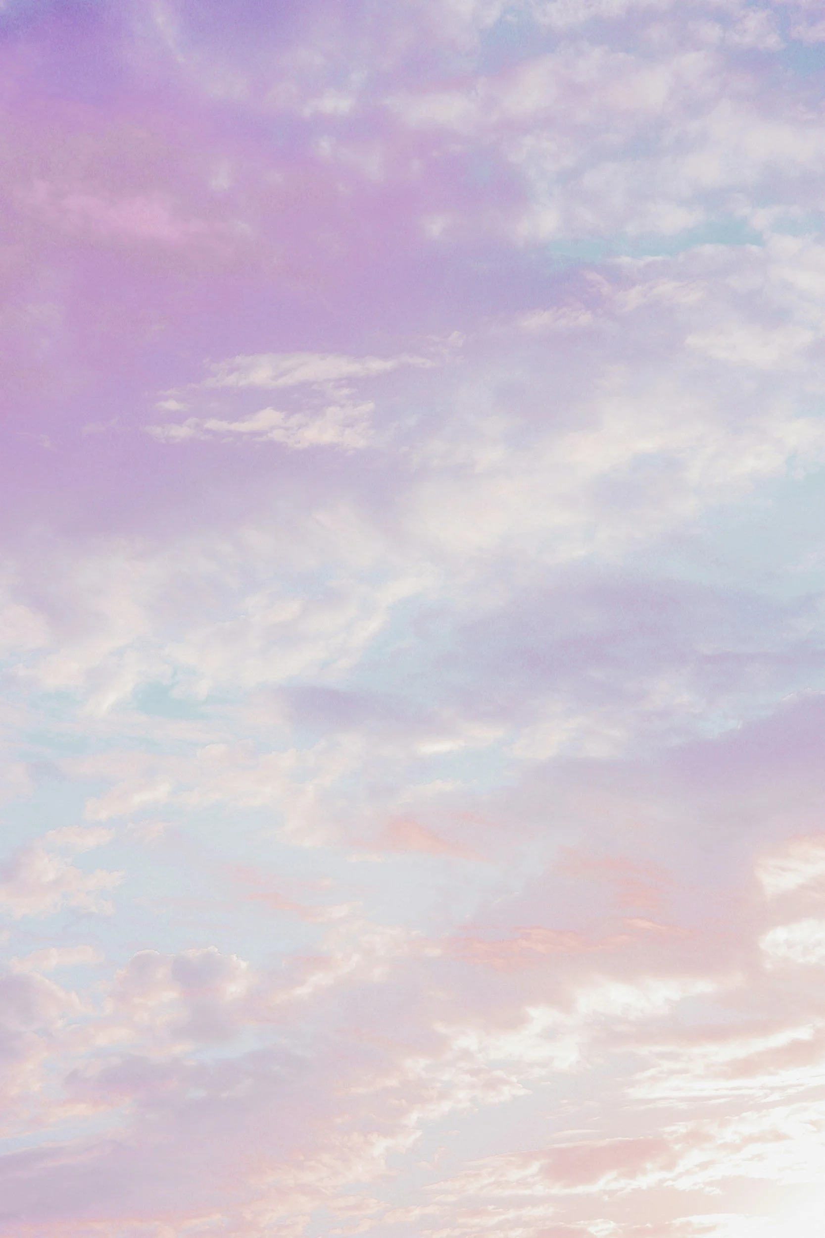 A pastel-colored sky with pink, purple, blue, and white clouds scattered across.