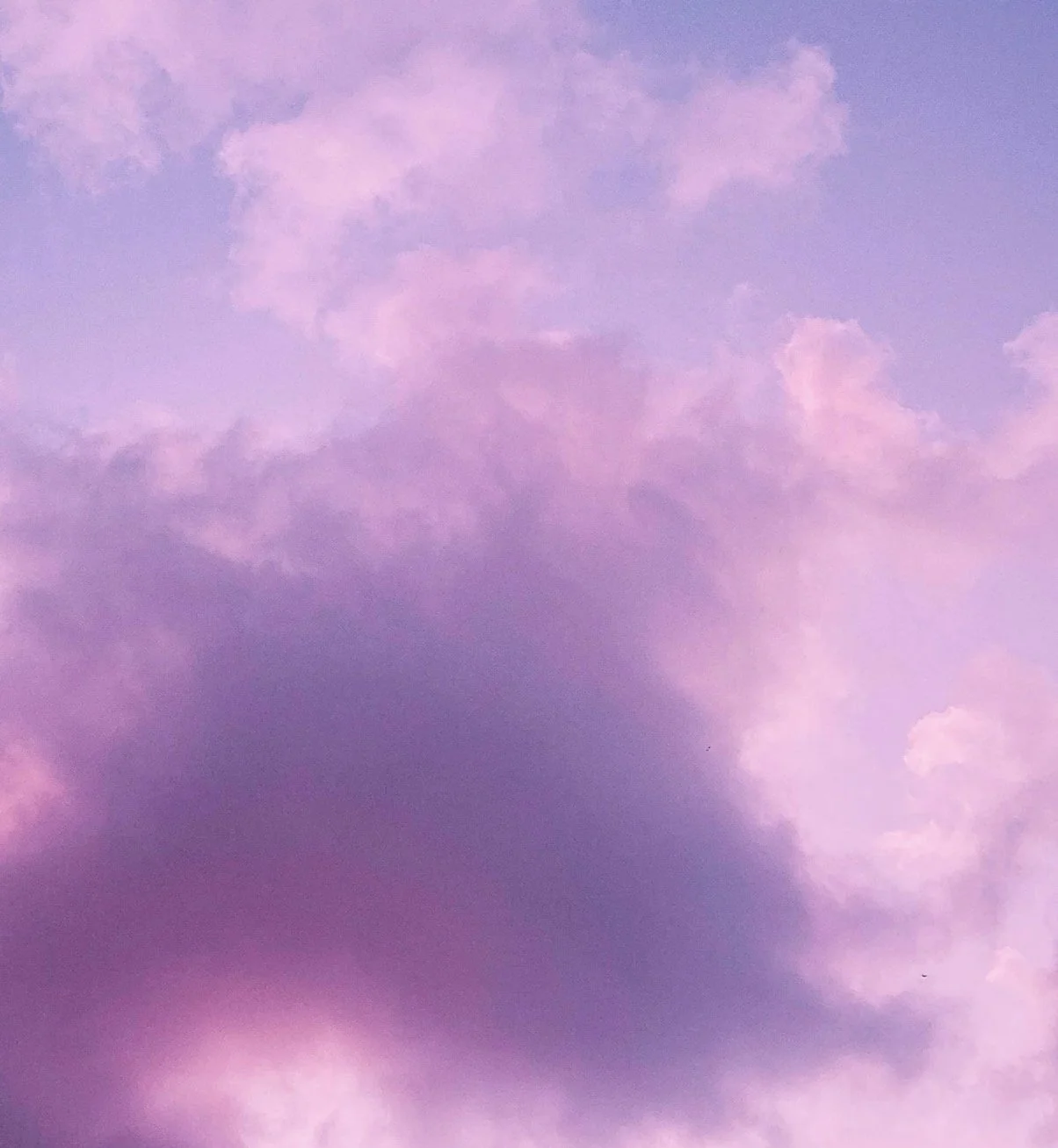 A sky filled with pink and purple clouds during sunset or sunrise.