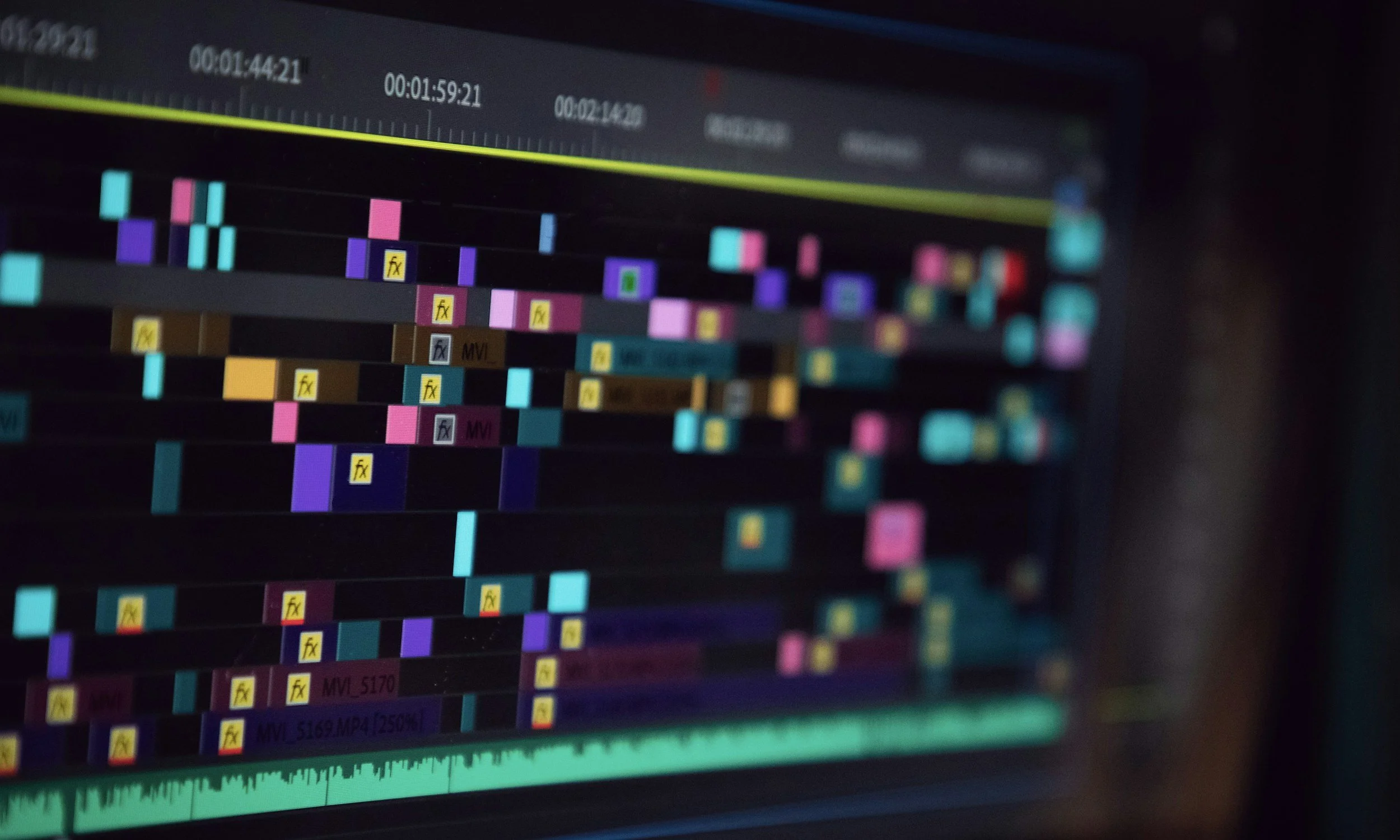 Photo of a computer screen displaying a video editing timeline with colorful clips, tracks, and timestamps.