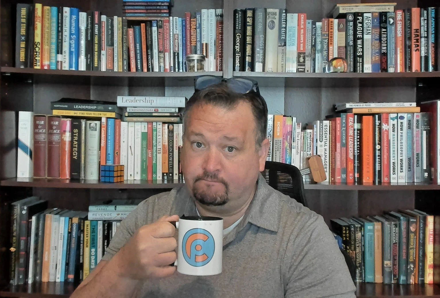 Dr. Adam Cubbage enjoys  cup of coffee while preparing for a discovery call.