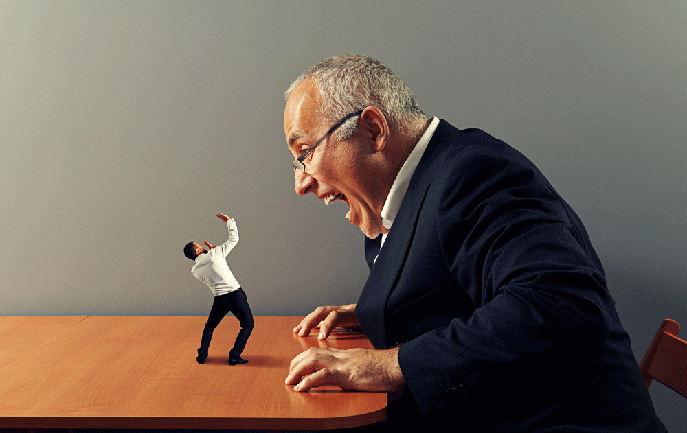 A giant man in a suit appears to be laughing or shouting at a tiny person on the table in front of him.