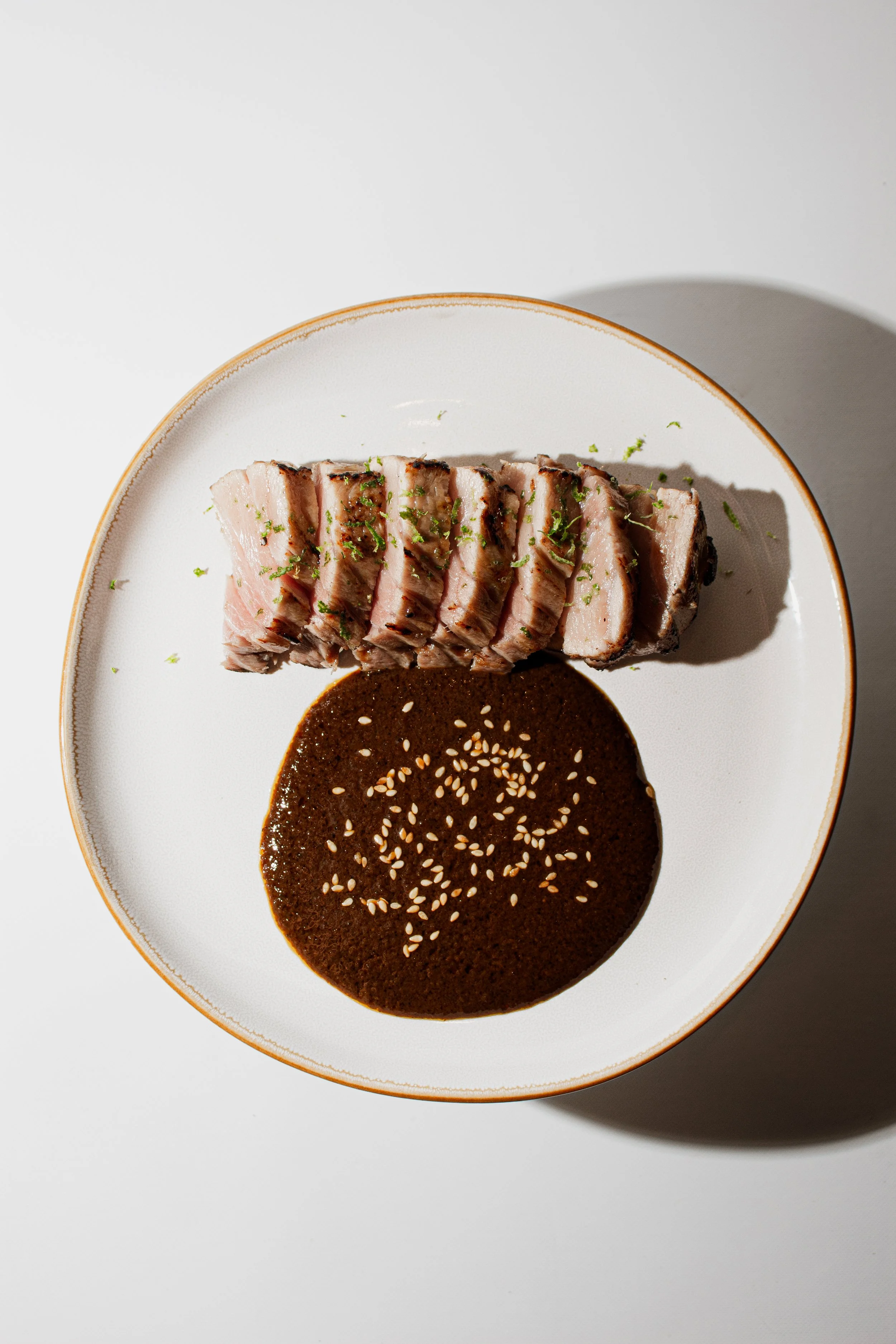 Seared tuna served with mole and sesame seeds at REMU Tulum.
