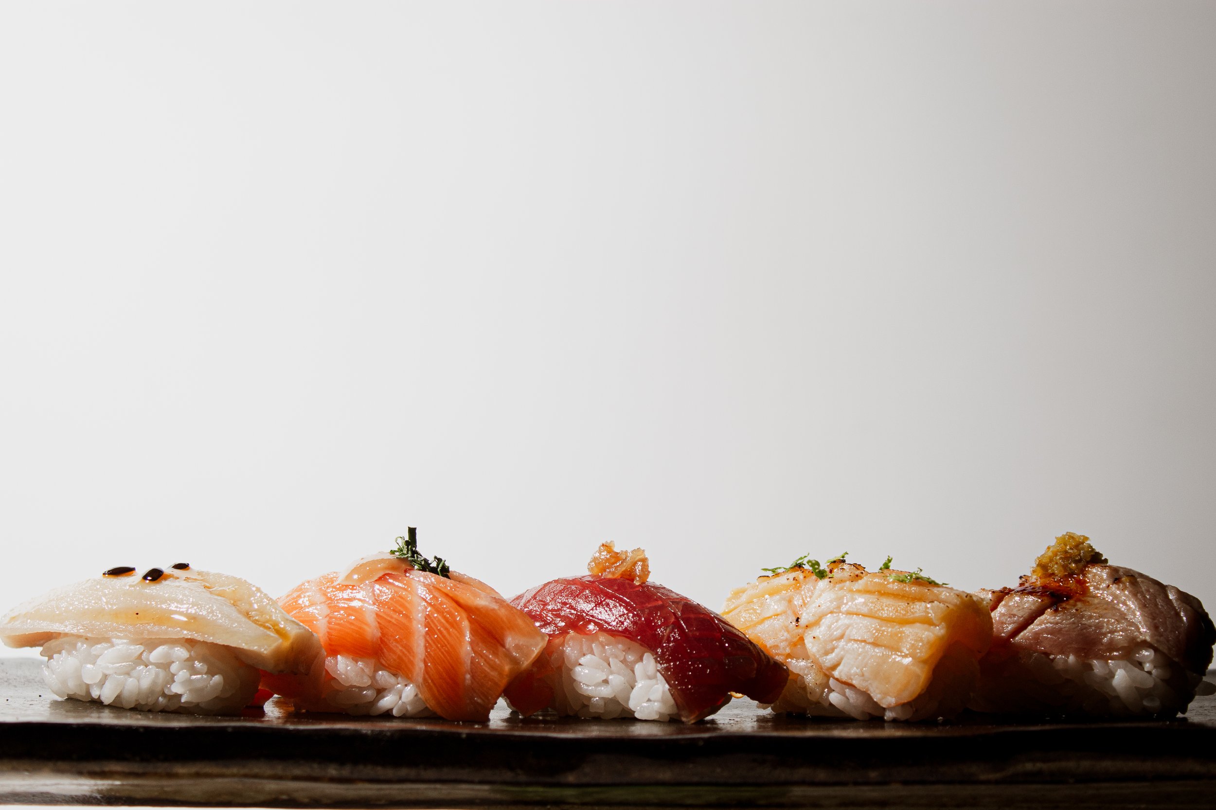 Selection of handcrafted nigiri featuring salmon, bluefin tuna, lightly torched fish, and otoro with yuzu kosho at REMU Matcha & Sushi Bar in Tulum.