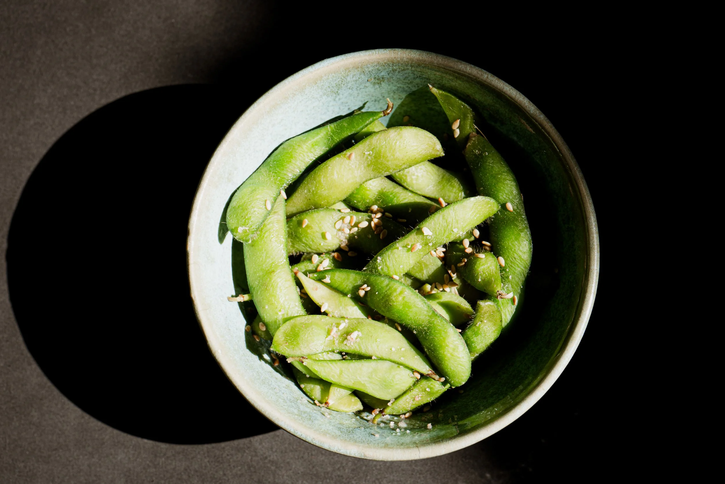 Steamed edamame topped with sea salt and sesame seeds served at REMU Tulum.