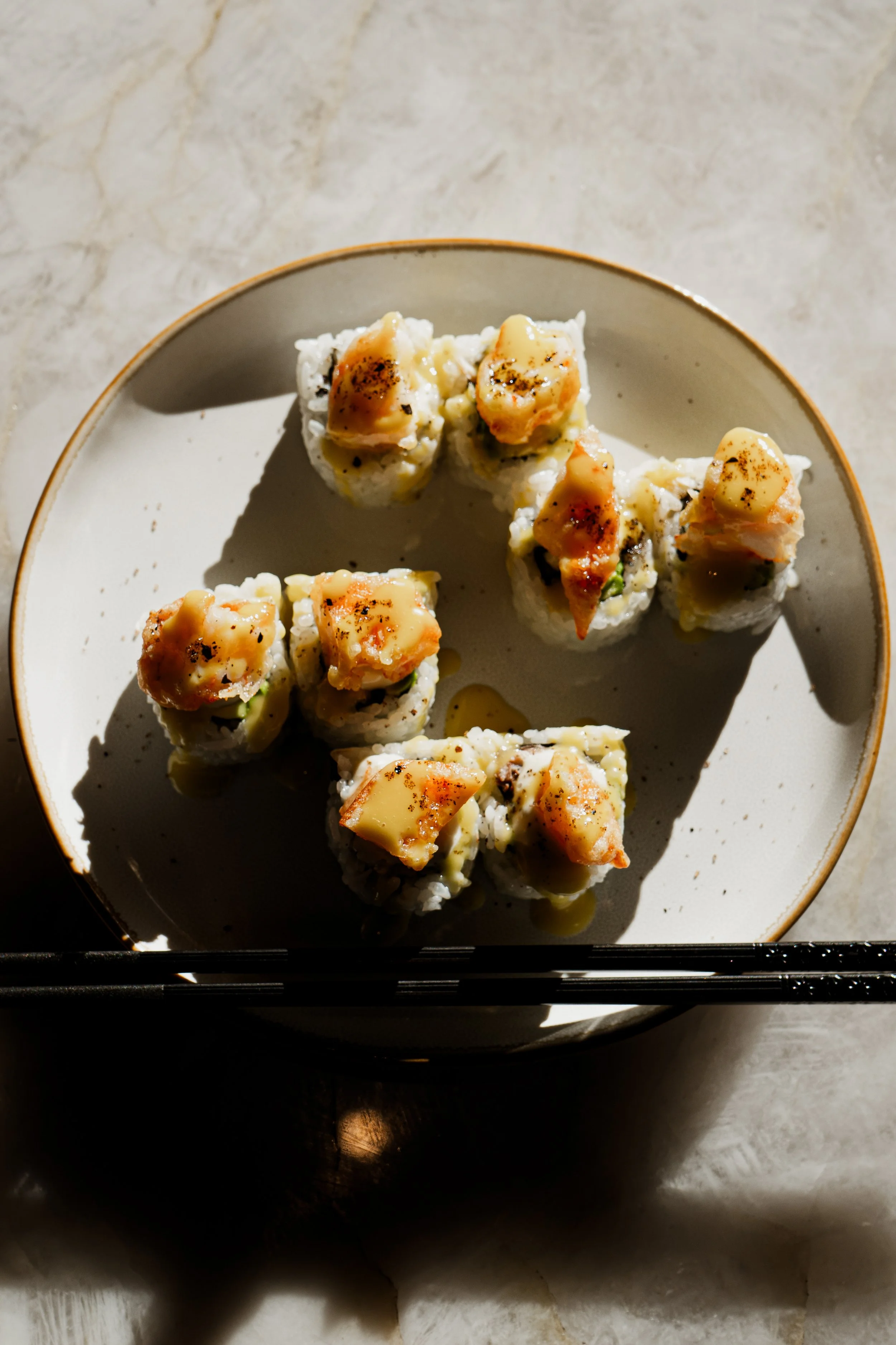 Sushi roll con scallops ligeramente flameados, salsa cremosa y arroz de sushi, servido en REMU Tulum.