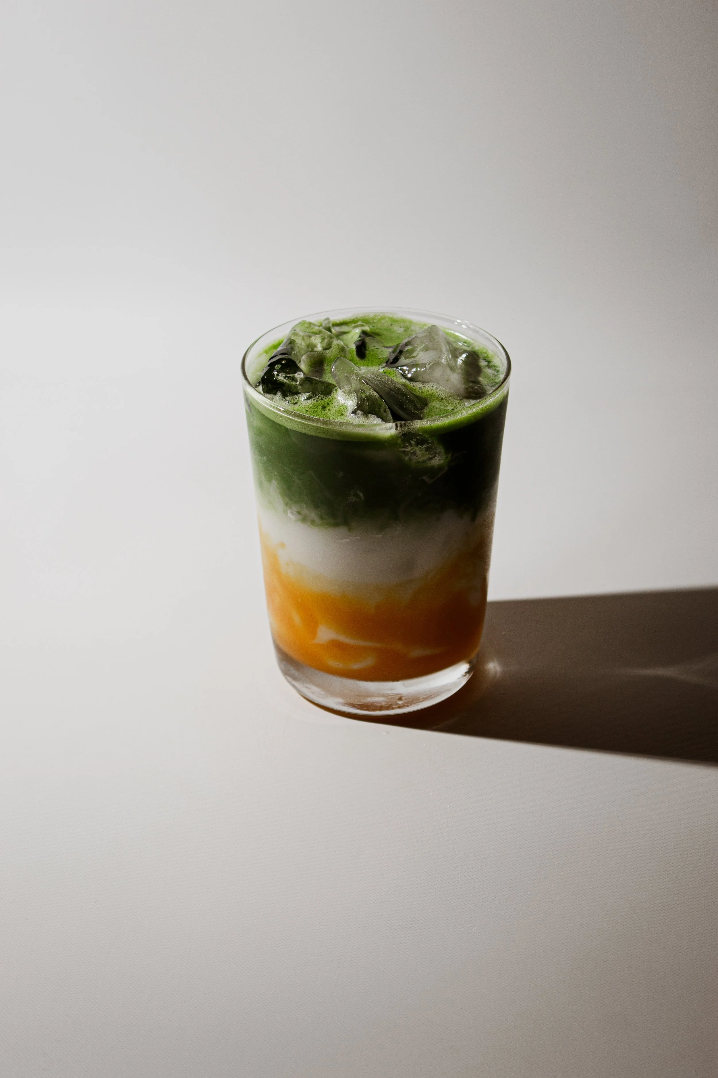 Iced matcha layered with mango and coconut cream served at REMU Tulum.