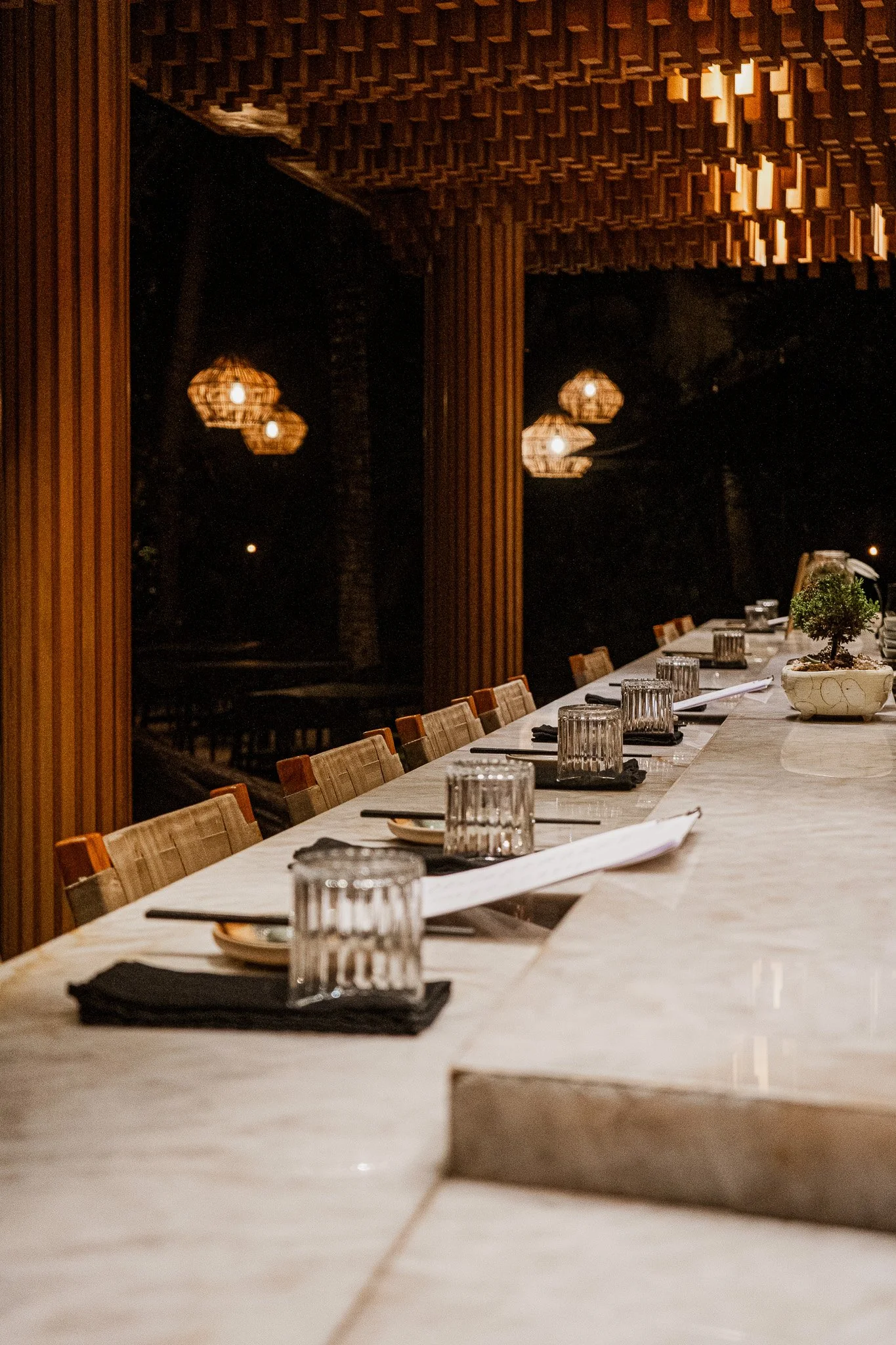 Dining space at REMU Tulum featuring warm lighting, natural materials, and an intimate atmosphere.
