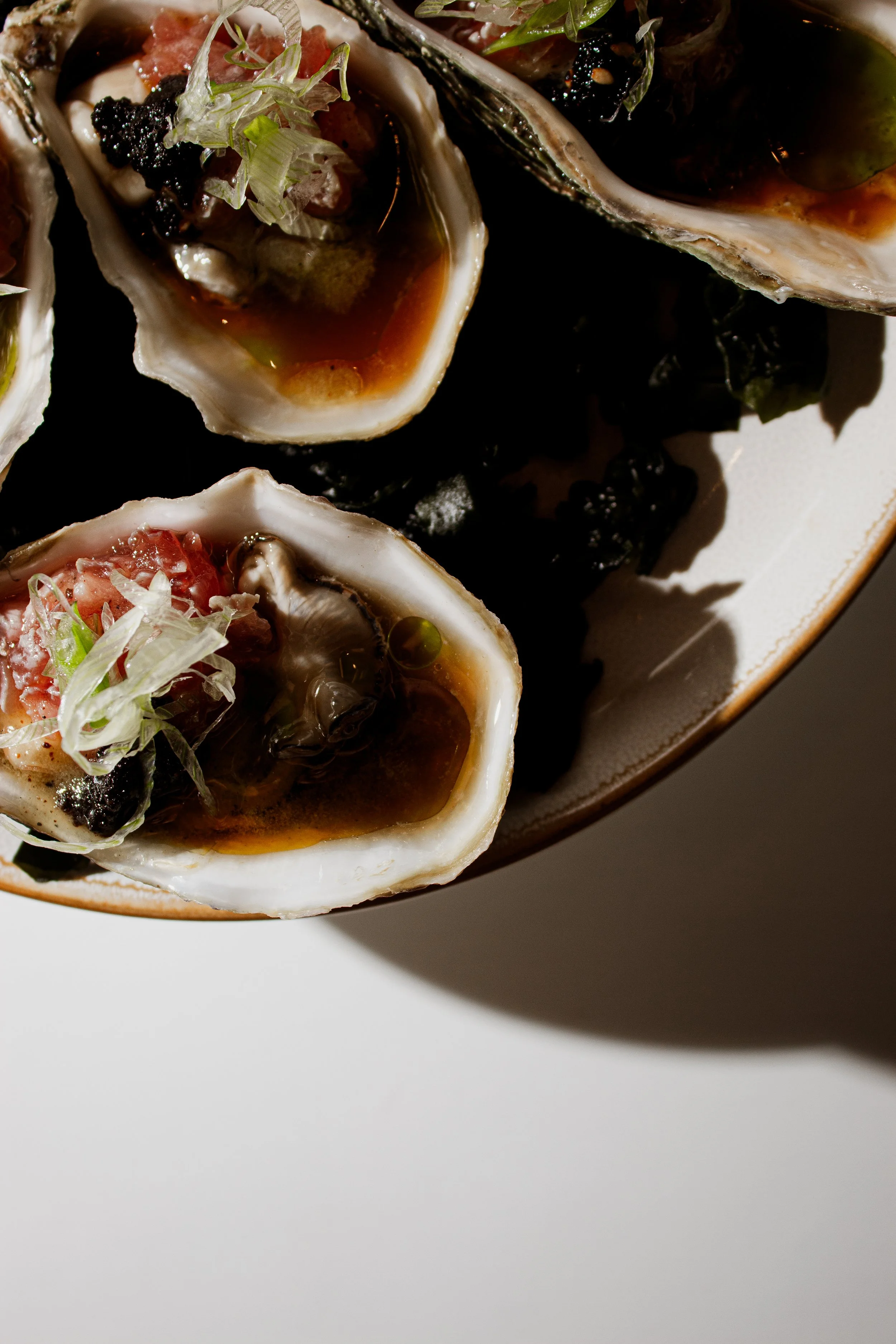 Fresh Japanese oysters topped with bluefin tuna, caviar and ponzu sauce at REMU sushi and matcha bar in Tulum.