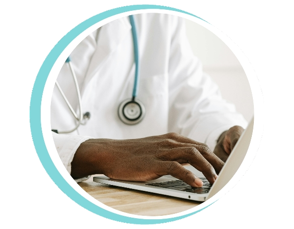 Close-up of a doctor using a laptop, with a stethoscope around their neck.