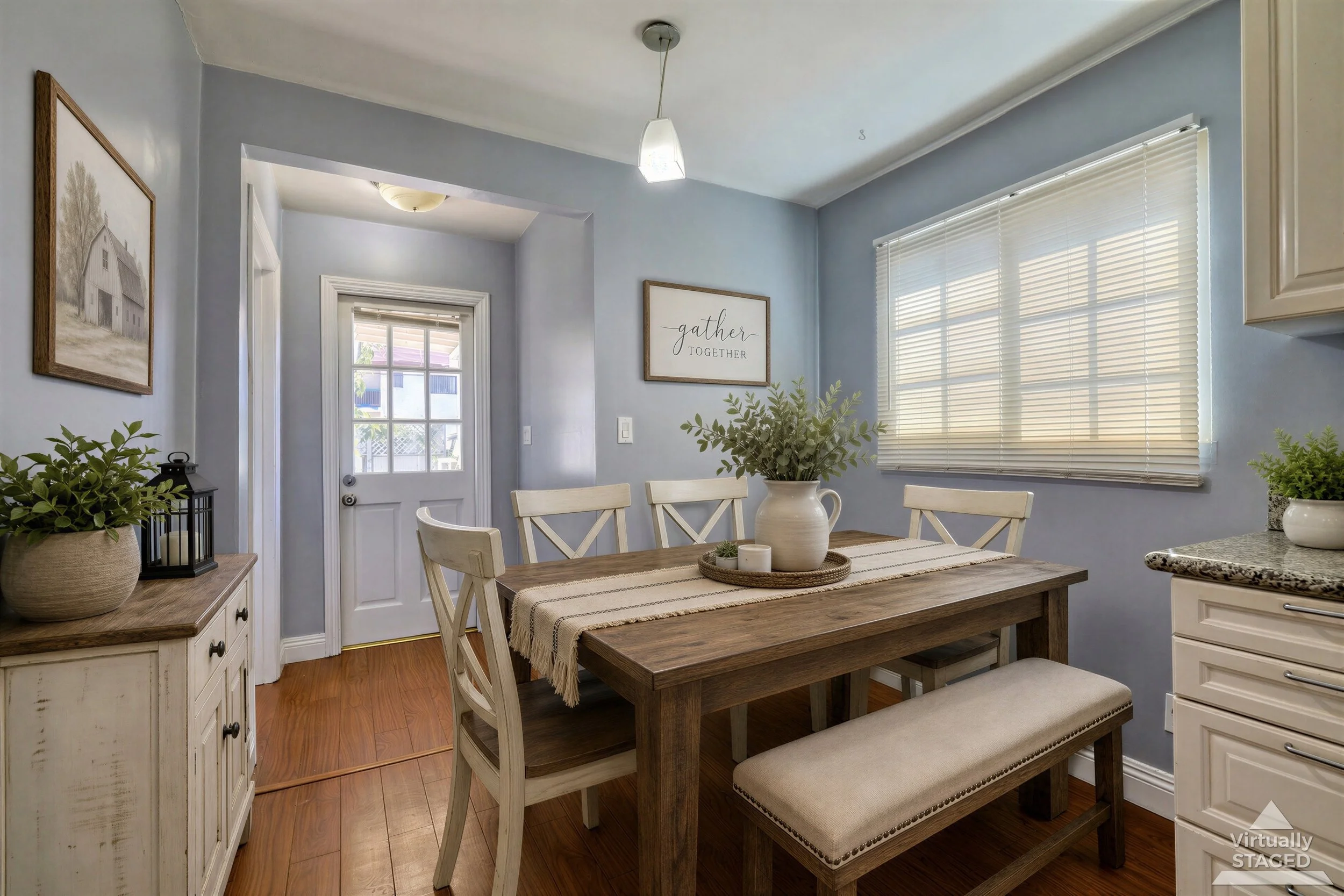 Professional real estate photo of virtually staged Burbank dining area with pale blue walls, wood table, and upholstered bench