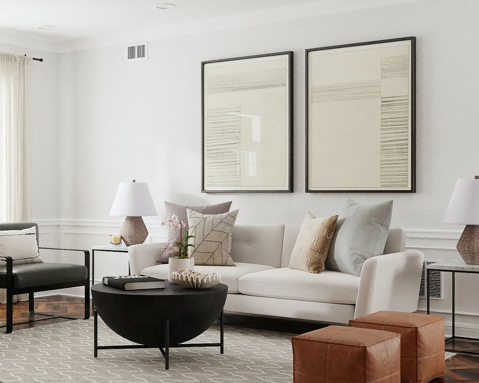 Living room with white sofa, black armchair, coffee table with decor, and framed art on white walls.