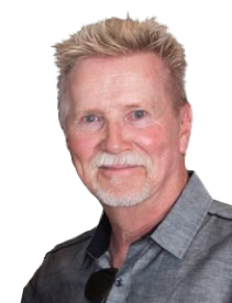 Portrait of a middle-aged man with blonde hair and a beard, wearing a gray shirt, smiling softly.