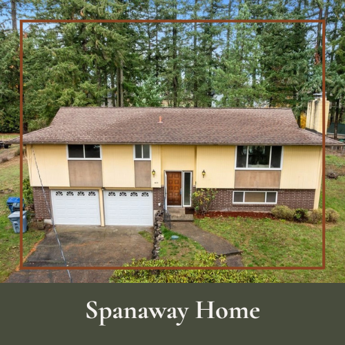 A two-story beige and brown home with attached garage, front porch, surrounded by trees and a grassy yard.