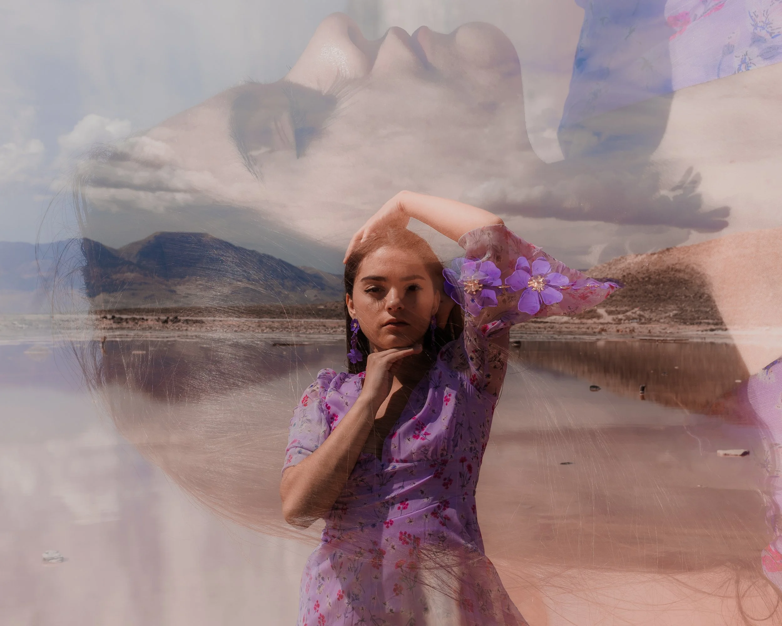 A woman lying on the beach with mountains and clouds in the background, wearing a floral dress and purple earrings, with an overlay of her portrait and a flower pattern.