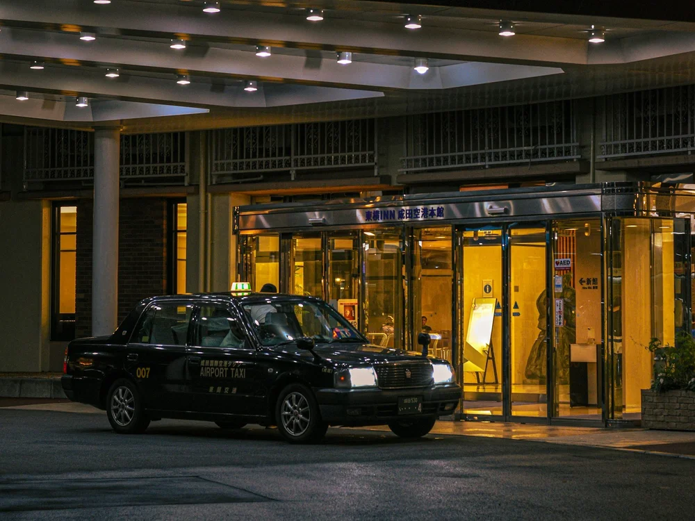 Lit hotel entrance at night, the kind of doorway a hotel staging investigator watches