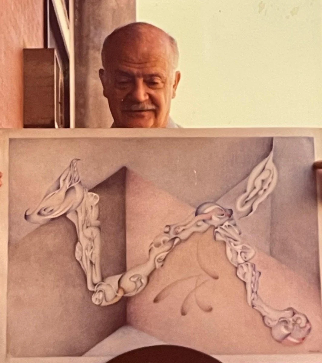 Elderly man smiling and holding a framed artwork with abstract shapes resembling a dog and a bird.