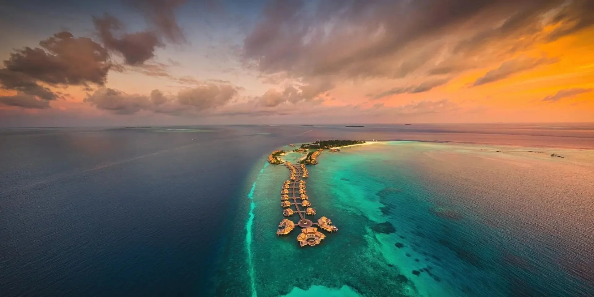 Luxury overwater bungalows at sunset in the Maldives — Tidal & Rare bespoke luxury travel, Amelia Island Florida