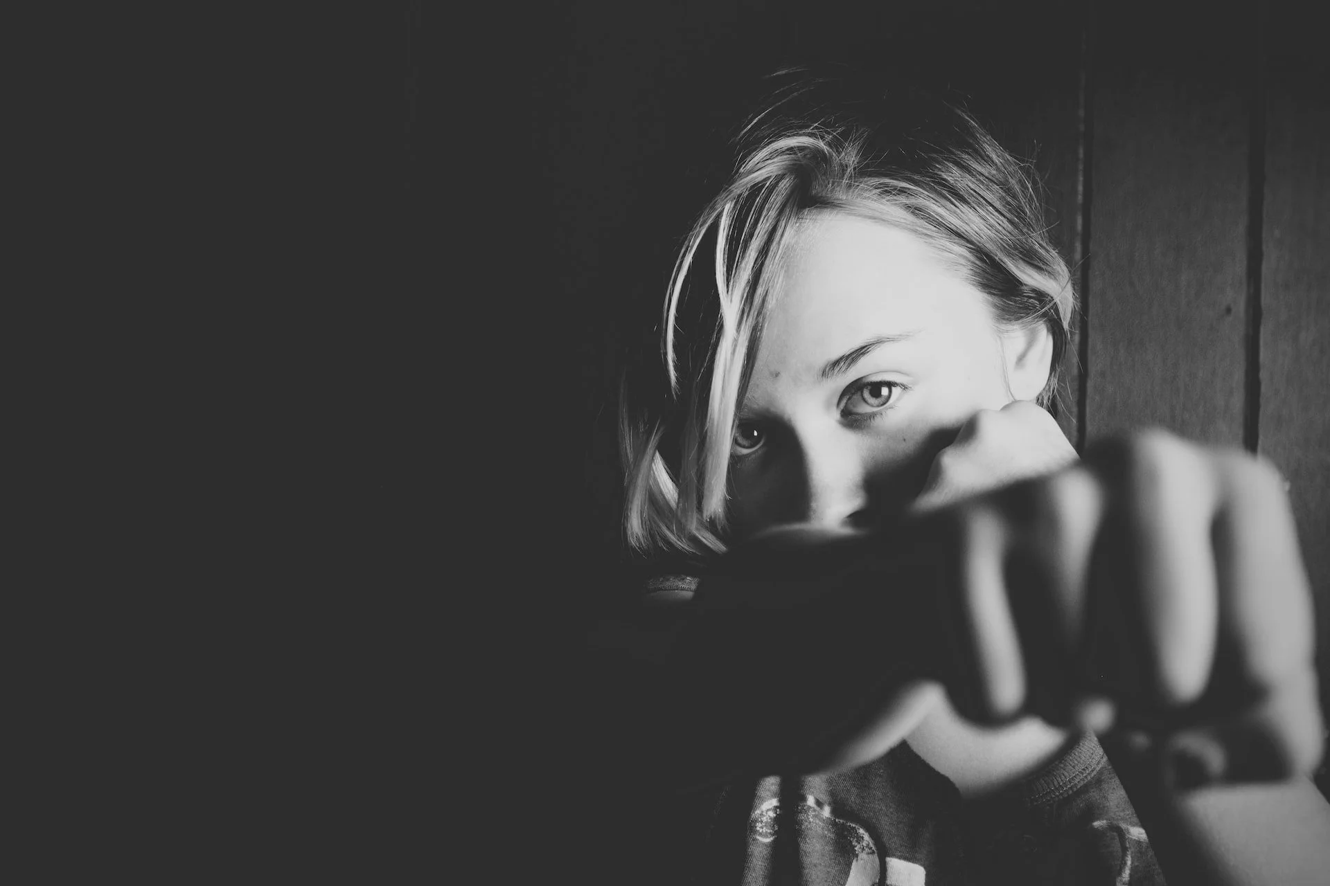 black-and-white photograph of a young woman throwing a punch