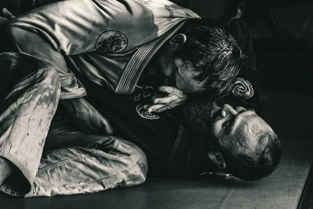 Two men grappling in a BJJ class