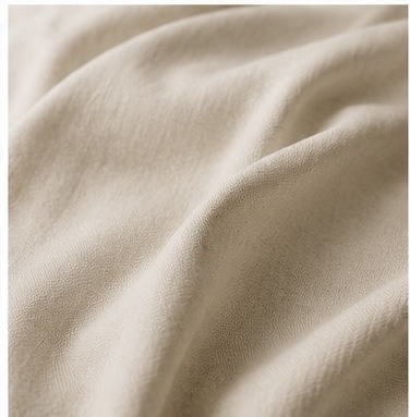 Close-up of beige fabric with soft folds and smooth texture.