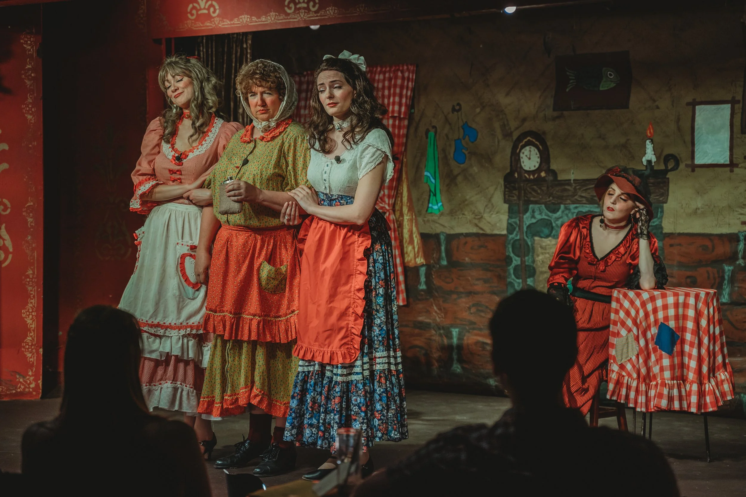 Four women dressed in vintage or costume clothing, standing on stage performing at Iron Springs Chateau, a dinner theater in Manitou Springs, Colorado.