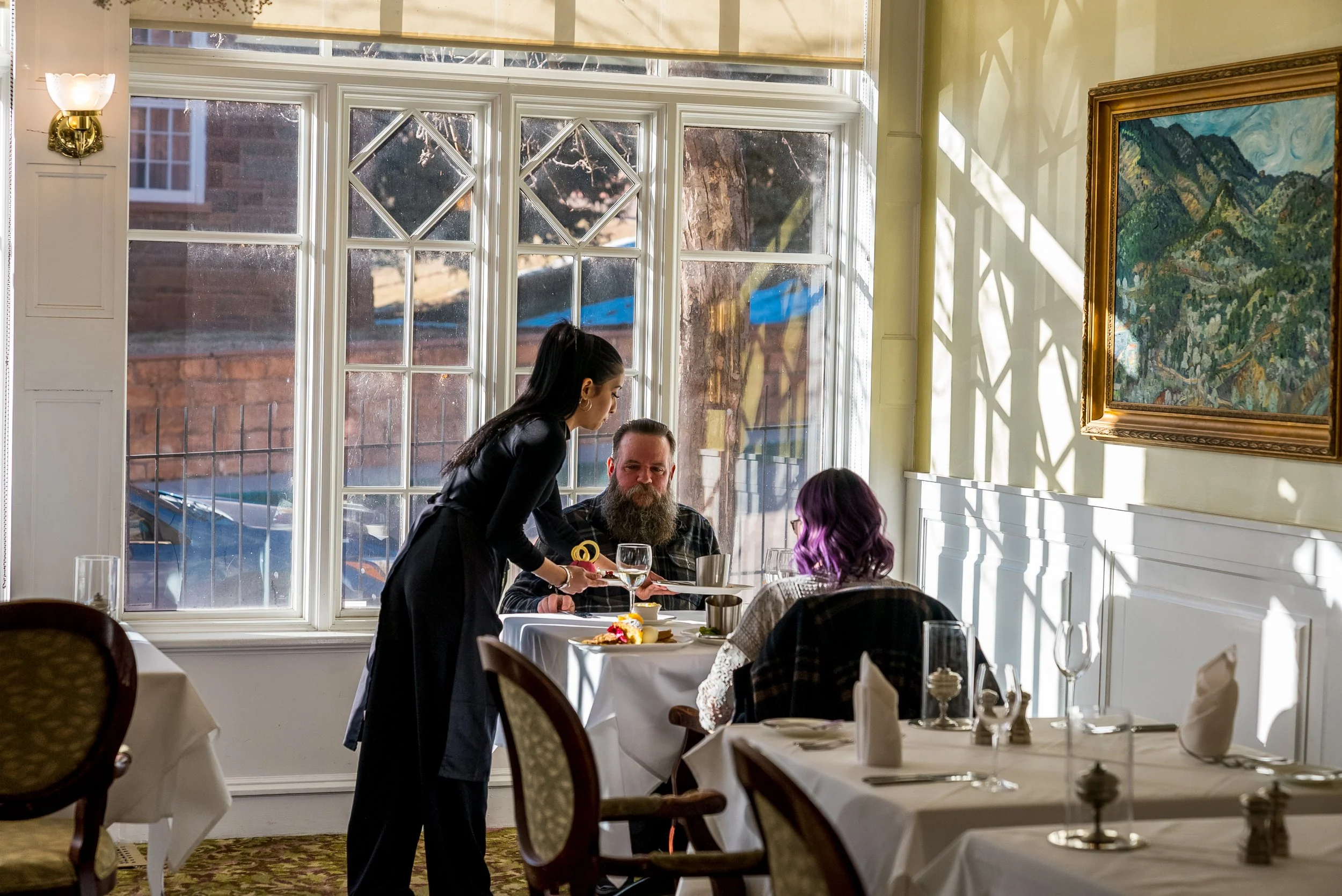 A man and woman are served table in a restaurant in downtown Manitou Springs, Colorado.