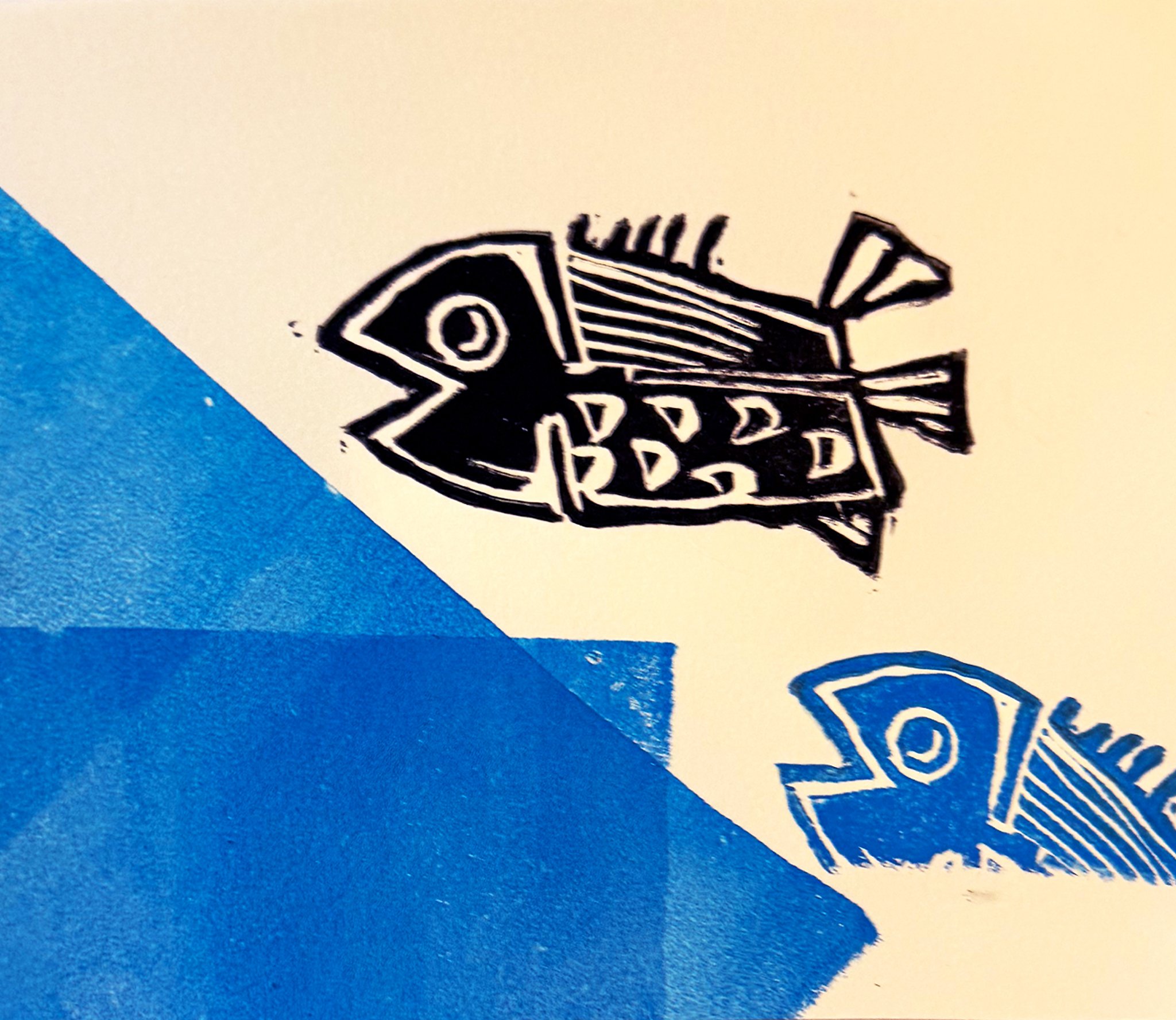 Close-up of a graphic of a fish on a piece of paper or card with blue and white background.