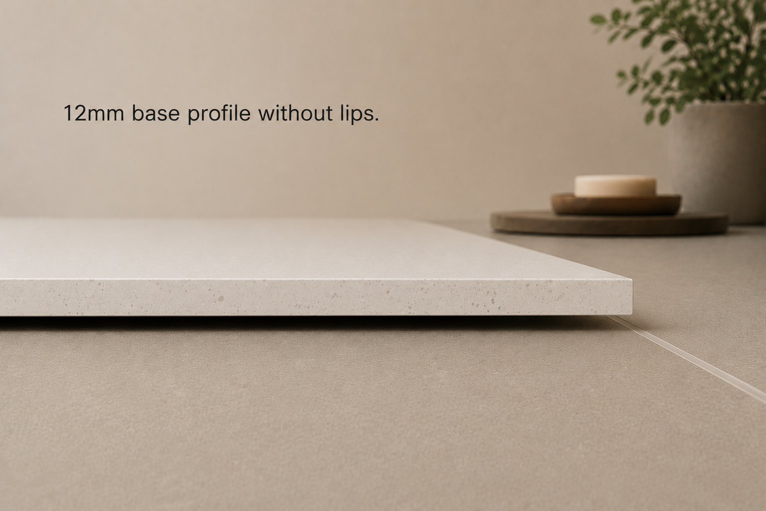 A close-up of a white 12mm wide base profile on a beige countertop with a potted plant and wooden trays in the background.