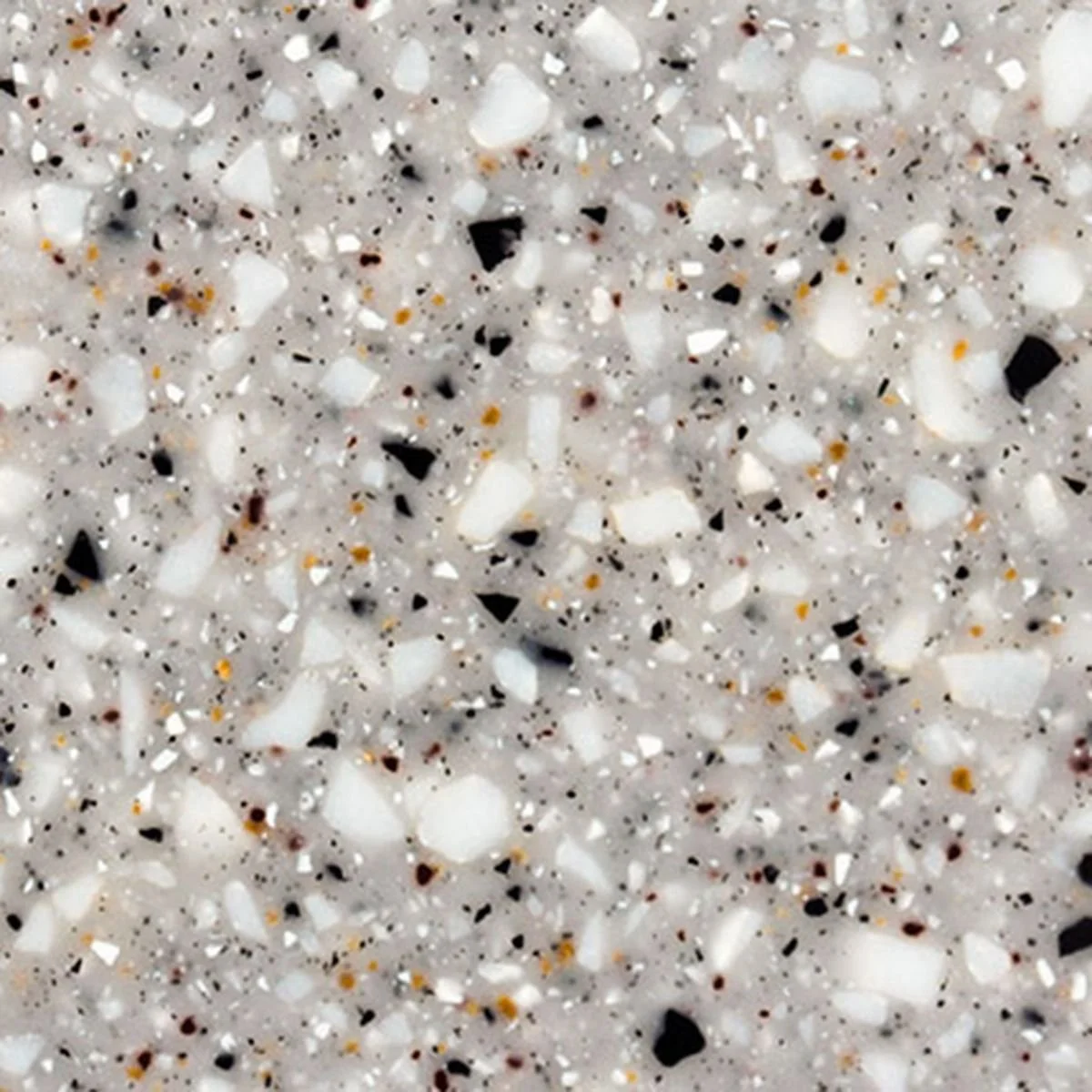 Close-up of a speckled Solid Surface, likely a granite or quartz countertop with white, black, and tan mineral flecks.