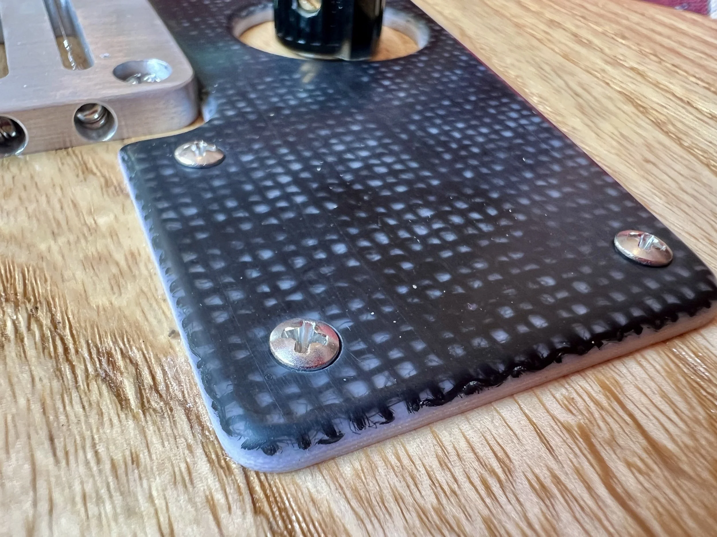 Ein metallener Gegenstand mit Schrauben auf einem Holztisch.