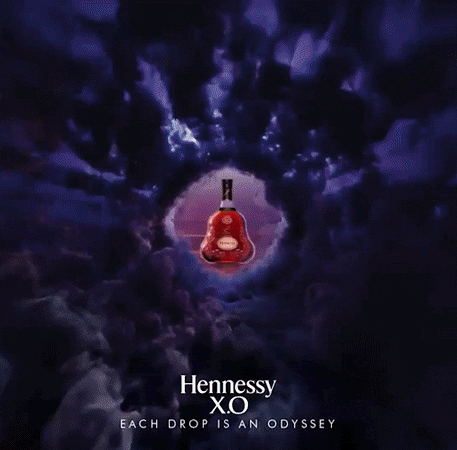 Une bouteille de Hennessy X.0 placée au centre d'un vortex ou une explosion de nuages sombres.