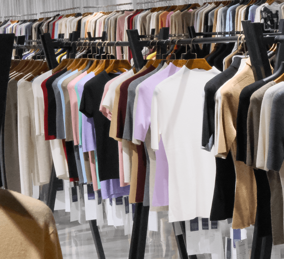 Knitted top samples displayed on garment racks, showing seasonal style references for knitwear development and sourcing.