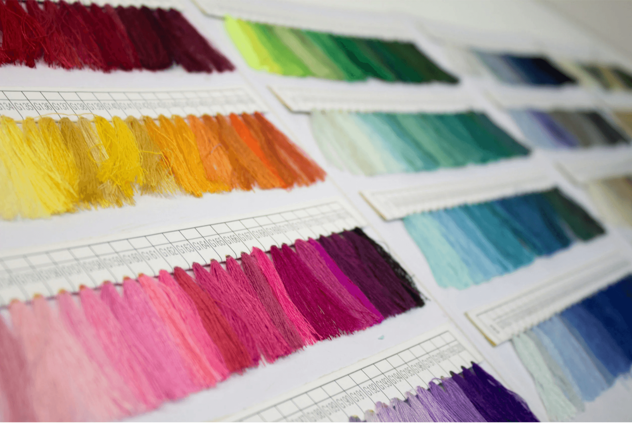 Color swatches organized in rows on a color sample chart, showing a gradient of hues from red and orange to pink and purple.
