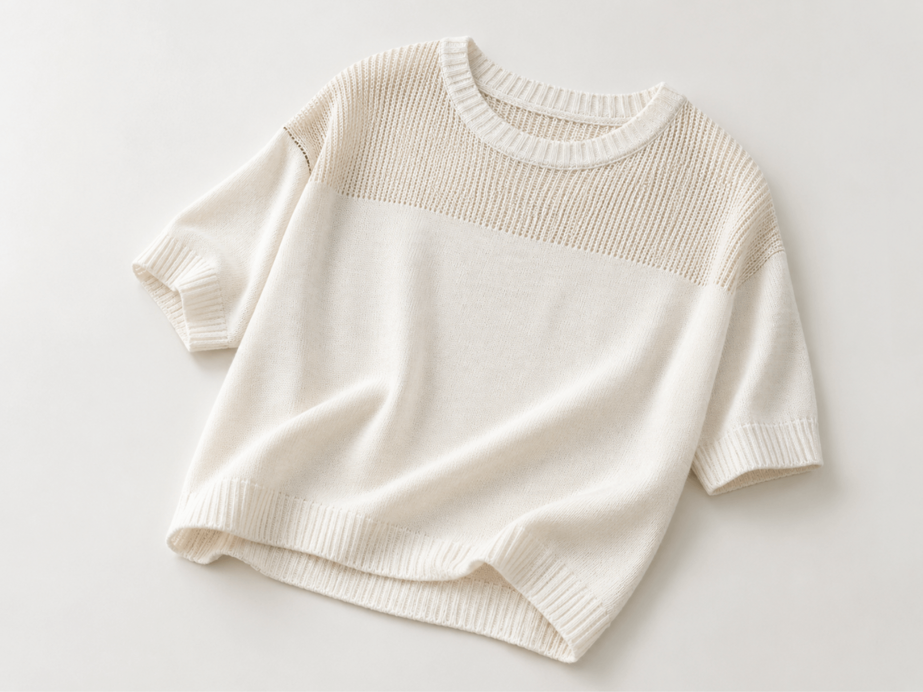 White short-sleeve knitted top with ribbed trims and a textured yoke, showing lightweight knitwear product direction.