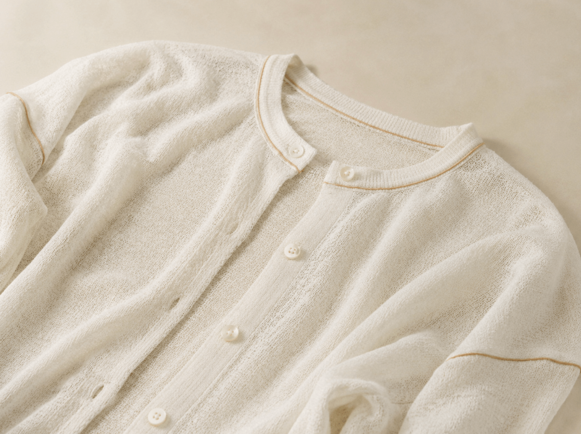 White lightweight knitted cardigan with button and seam details, showing a soft boutique-ready knitwear style.