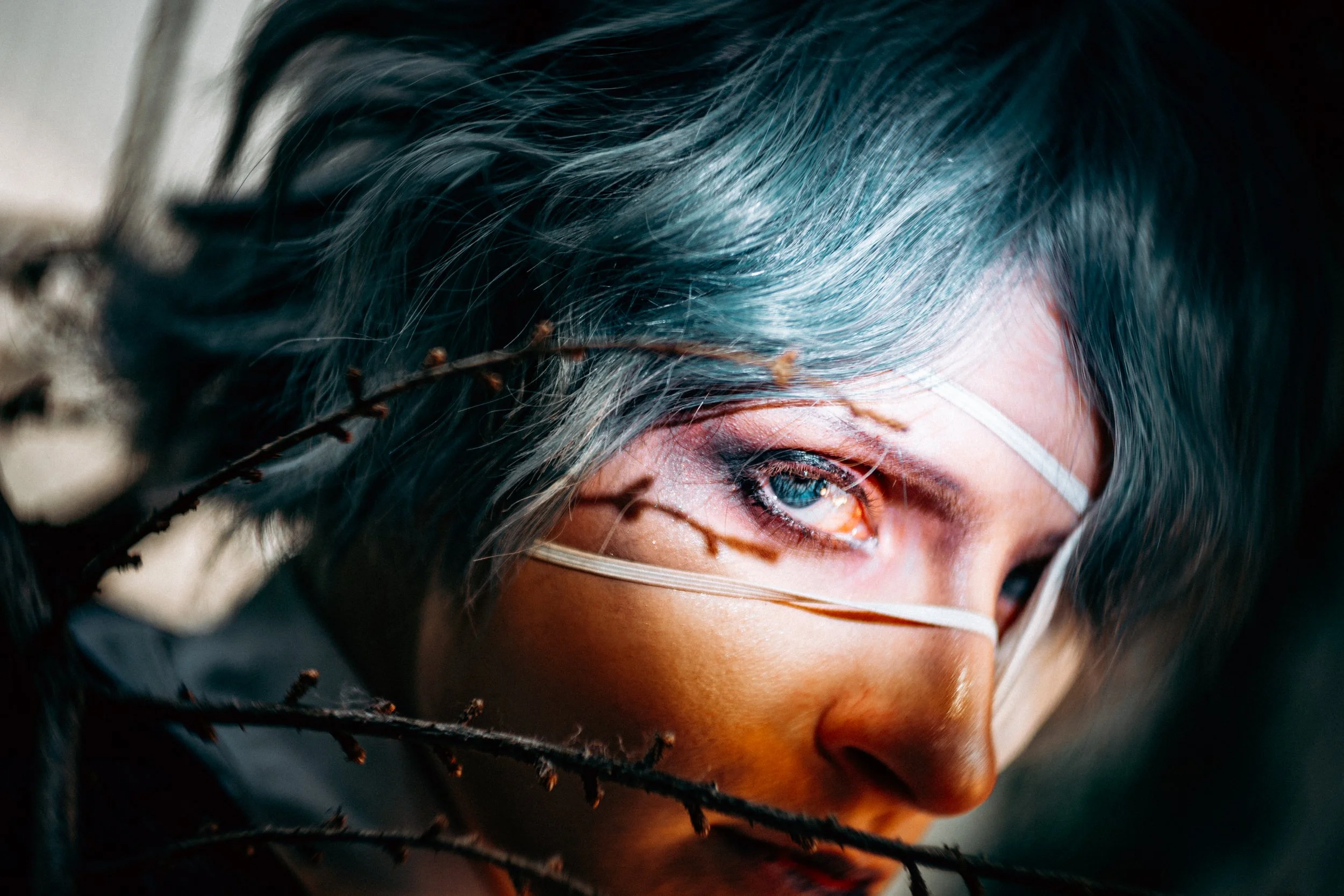 Primo piano occhio azzurro cosplay con ramoscelli, fotografia minimalista Progetto Anima Fusa