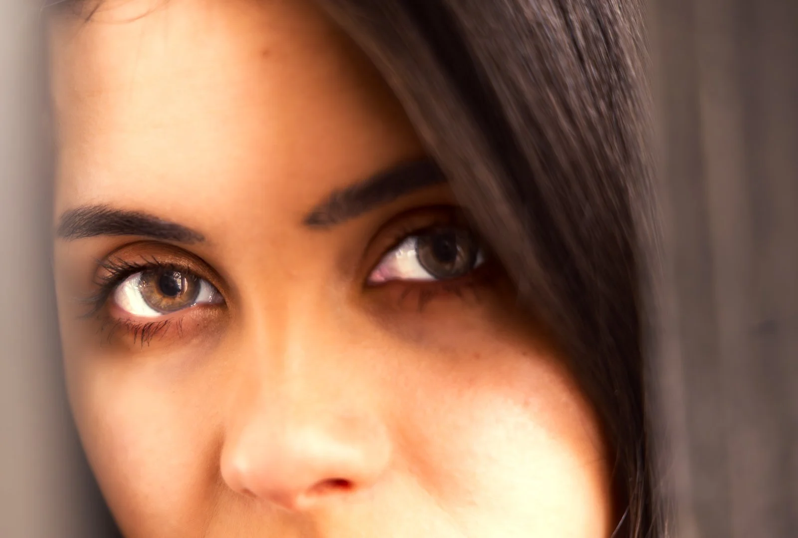 Close-up of a woman's face showing her eyes, eyebrows, and part of her hair.