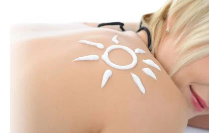 A woman lying on her side with sunscreen applied in a sunburst pattern on her shoulder. To suggest spray tanning