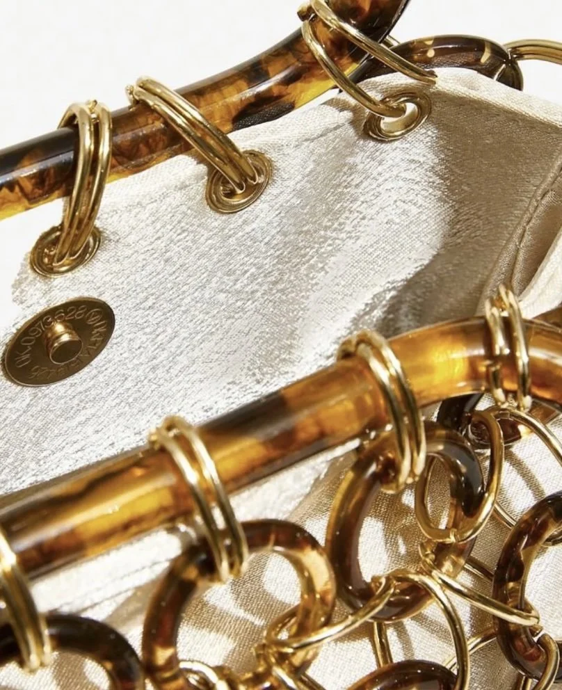 Detail of the Portico Bag with tortoiseshell handles and gold chain hardware.