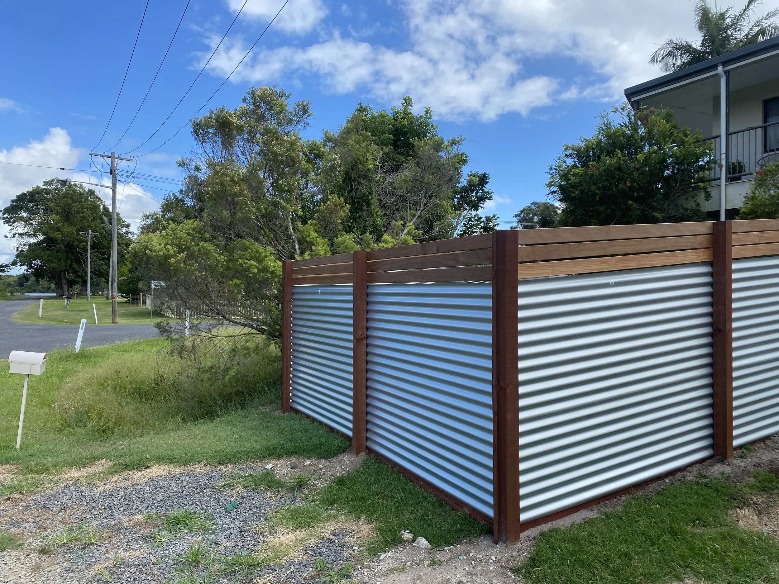 Custom timber and metal front feature fence. Merbau screening with horizontal corrugated zincalume sheets.