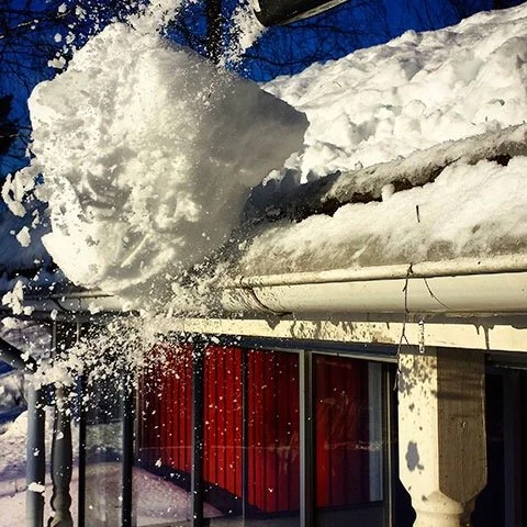 Déneigement de toiture  devant un bâtiment à Beloeil