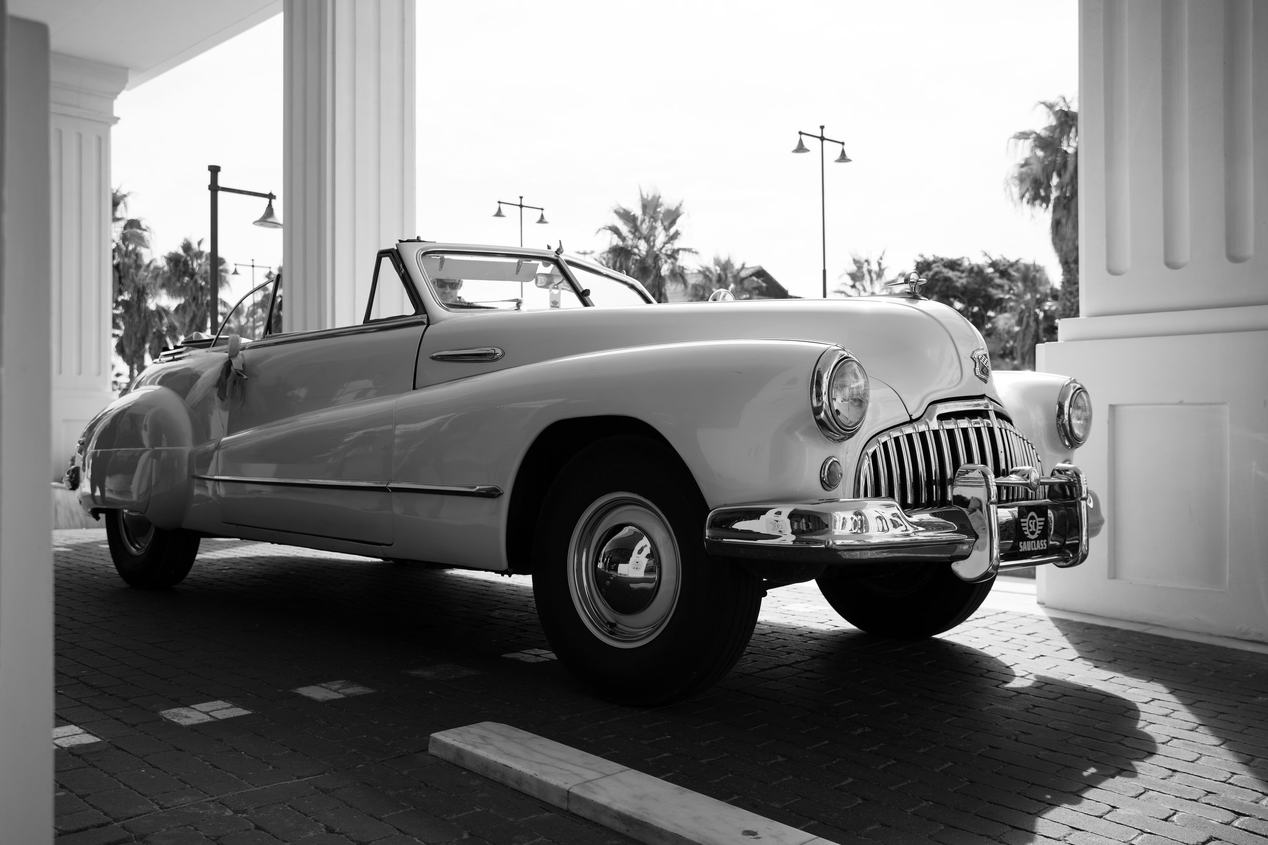 Coches clásicos en un espacio abierto, en blanco y negro.