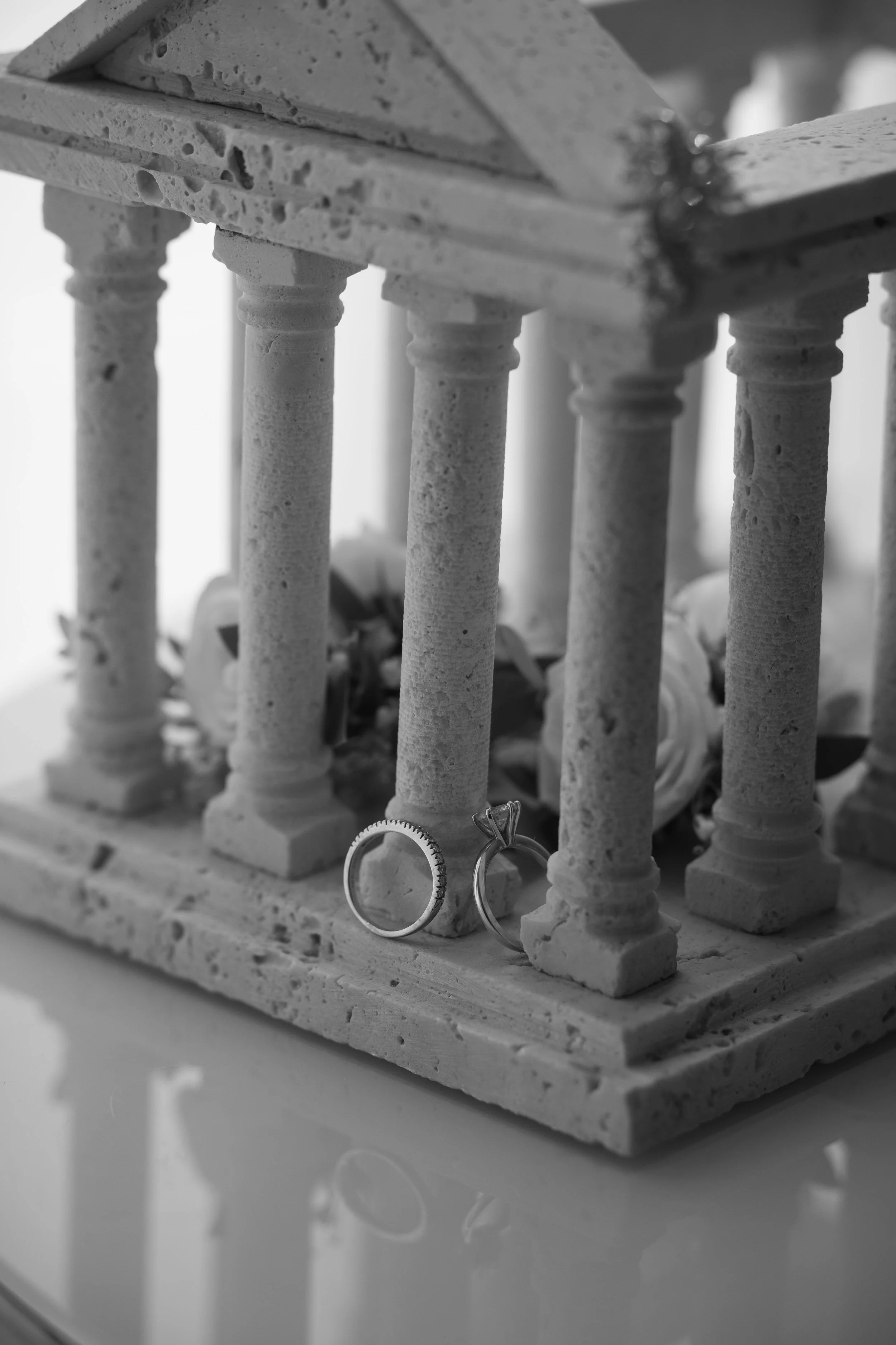Rings hanging de un soporte de madera con columnas de piedra en blanco y negro.